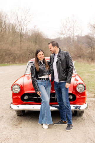 man and woman couple standing in front of an antique red car for valentines day pictures in Cincinnati, Ohio