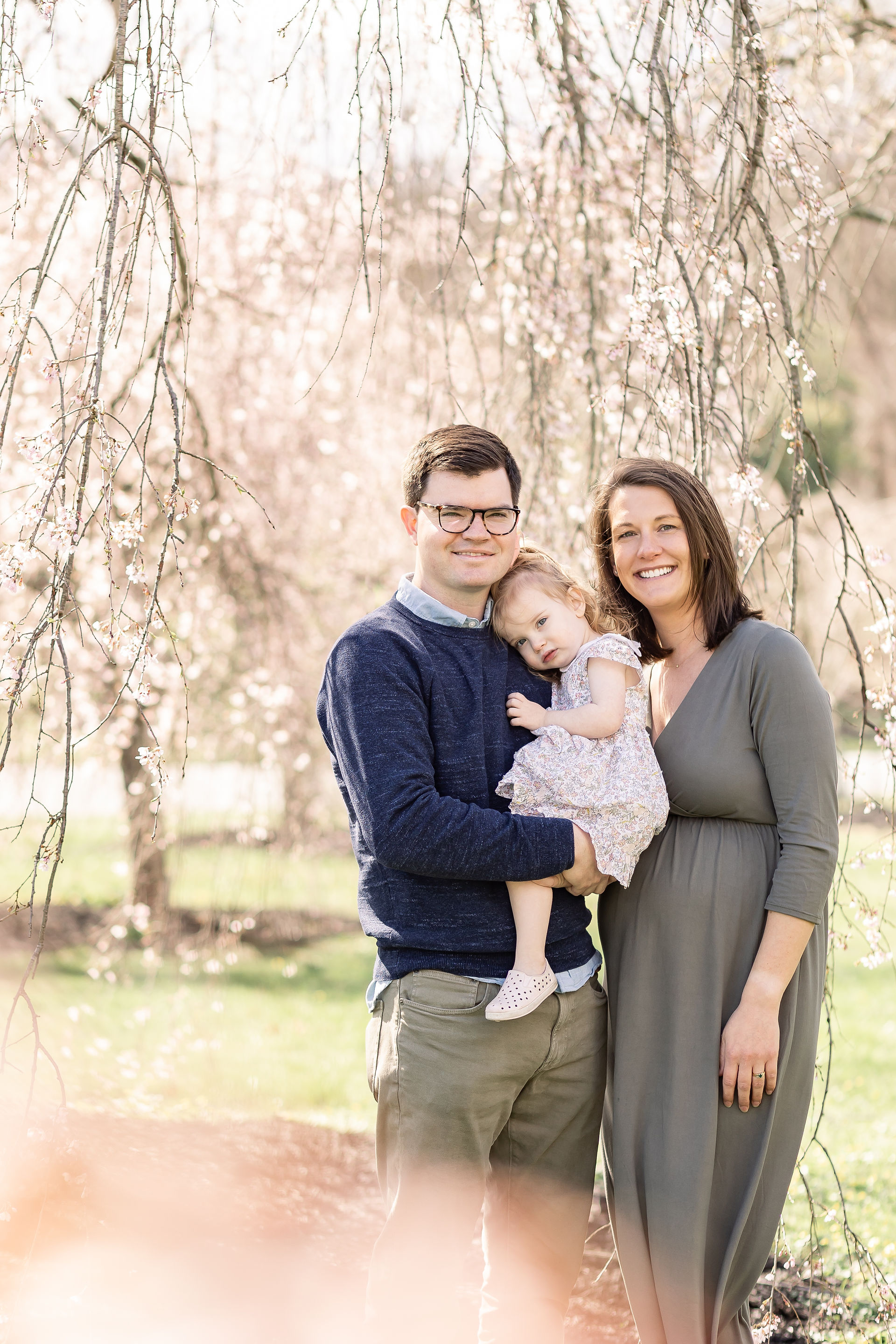 family photo with cherry blossoms; mommy, daddy, and little girl