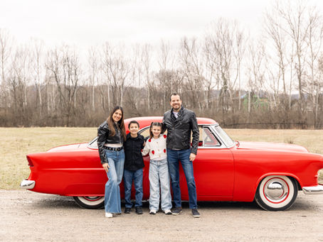 family standing in front of an antique red car for Valentine's Day pictures in Cincinnati, Ohio