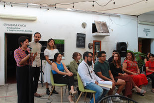 Un grupo de artistas sentados esperando su turno para exponer sus obras.