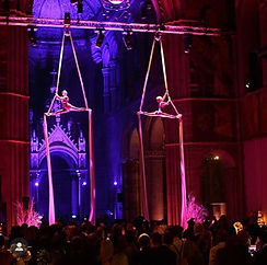 2 aerialists doing the splits on aerial silks