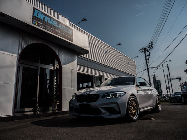 Drive. MOTOR SPORTの店舗前に停車するBMW M2