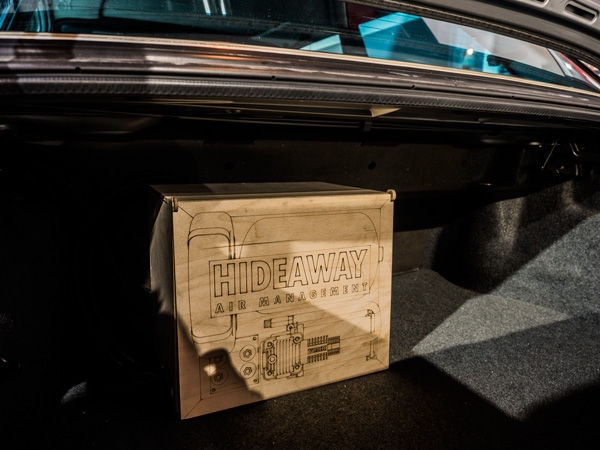 車のトランク内に配置されたHIDEAWAY AIR MANAGEMENTのロゴ入り木製ボックス