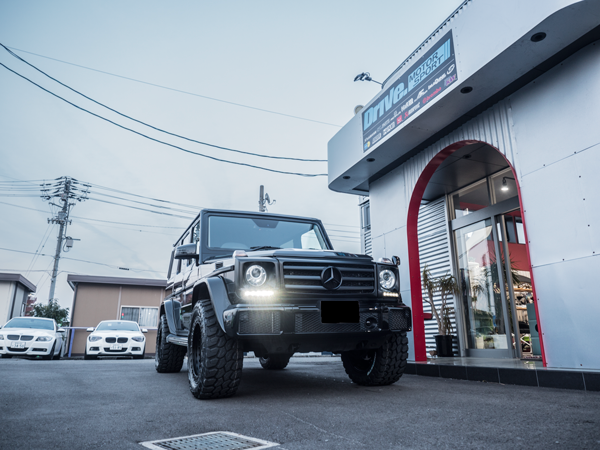 Drive. MOTOR SPORT店舗前に停車する黒のメルセデス・ベンツ Gクラス