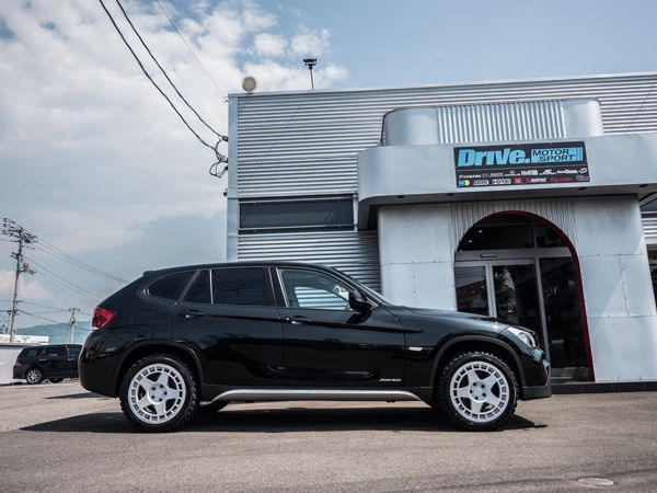 Drive. MOTOR SPORT店舗前に停車する黒のBMW X1