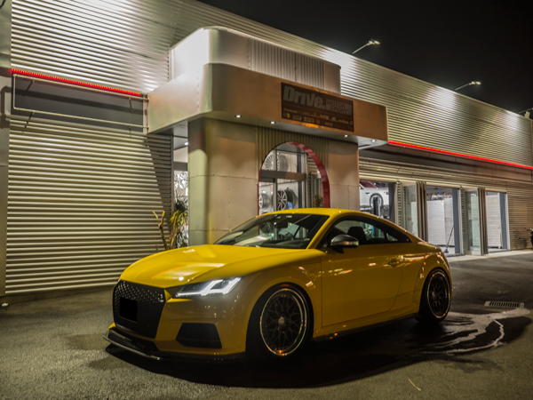 夜のDrive. MOTOR SPORT店舗前に停まる黄色いアウディTT