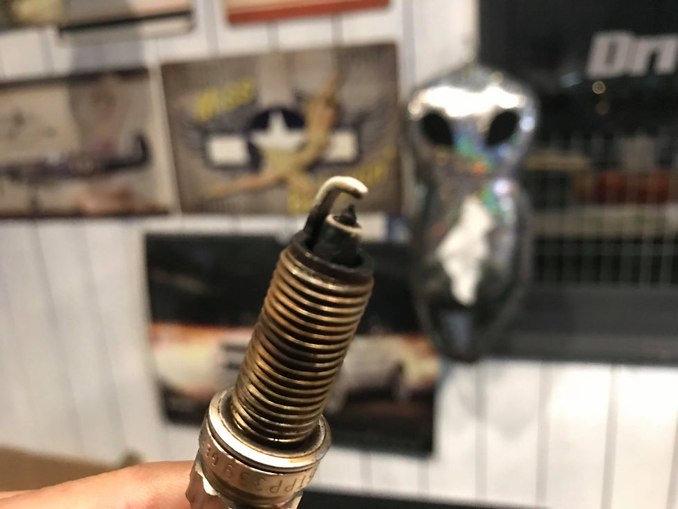 先端にカーボンが堆積し黒く汚れたスパークプラグの接写