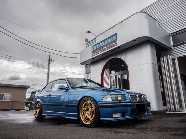 Drive. MOTOR SPORTの前に停まる青いBMW E36