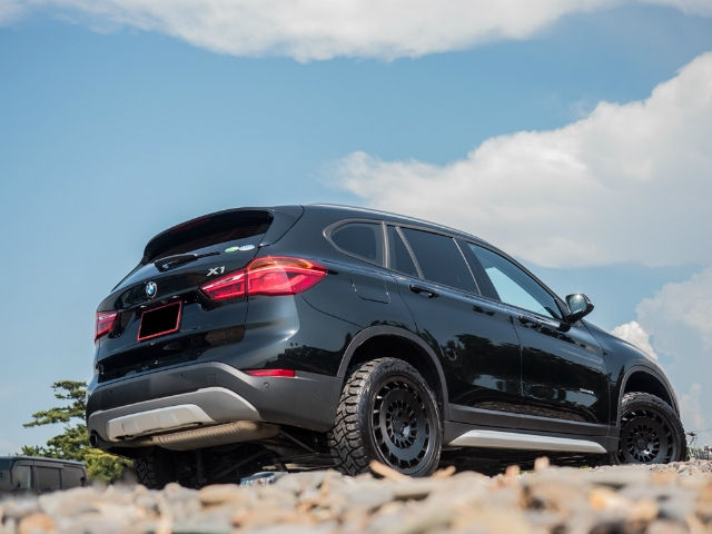 オフロードタイヤを装着した黒のBMW X1の後方斜め姿