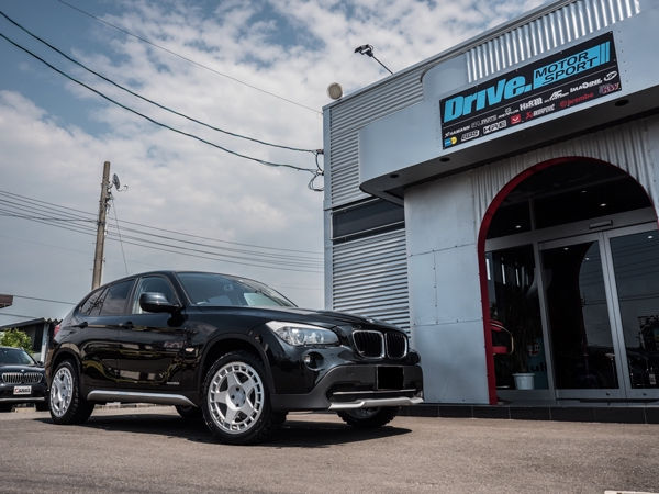 Drive. Motor Sport店舗前に停車する黒のBMW X1
