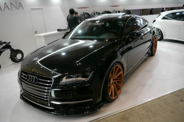 展示会に並ぶ銅色のホイールを履いた黒いアウディのカスタムカー