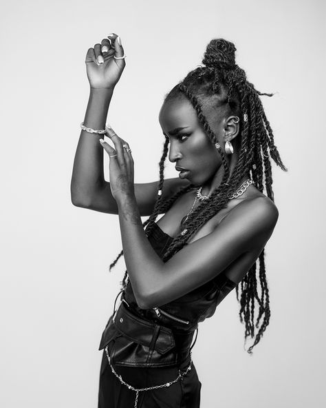 Model cu coafură răsucită și vestă de piele într-o fotografie alb-negru realizată în studio – portret fashion editorial cu atitudine