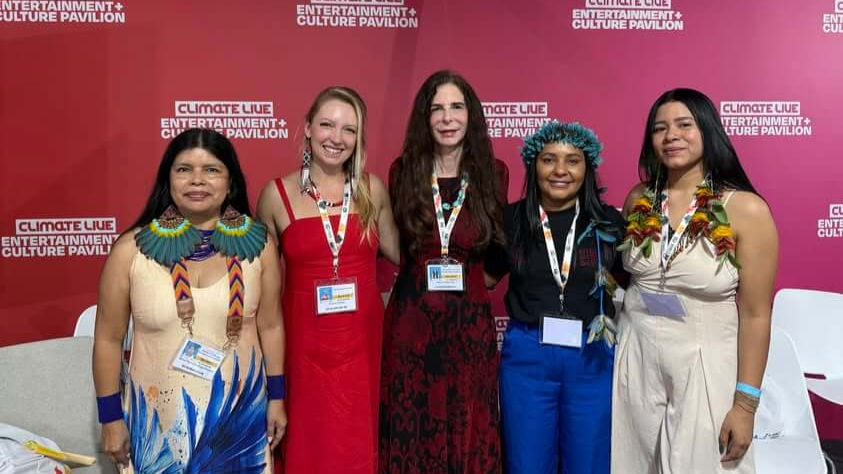 (Left to right) Patricia Gualinga (Kichwa), Chelsea Greene, Osprey Orielle Lake, Secretary Puyr Tembé (Tembé) and Lidia Guajajara (Guajajara) at the WECAN and We Are Guardians event “Guardians of the Future: Women Leading Forest Protection & Cultural Resilience” held on November 18 during COP30 in Belém, Brazil. Photo credit: Katherine Quaid / WECAN