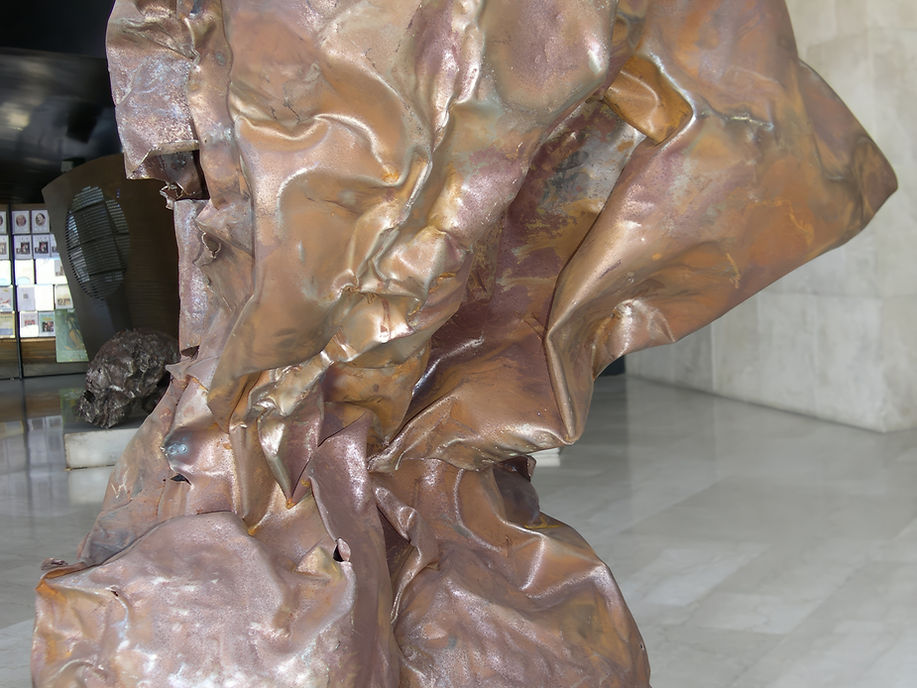 Close up of a beaten steel mixed media sculpture titled Tel Hashomer from 2009 showing the folded and textured metallic surface with warm copper tones