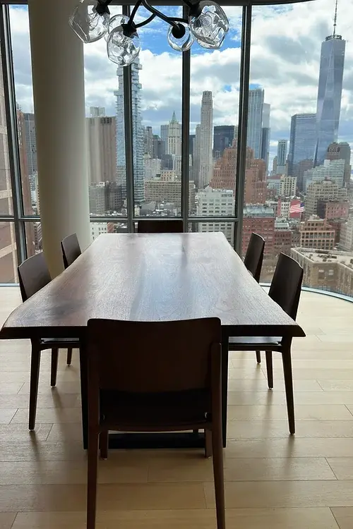 Live edge black walnut dining table with blackened steel legs in a Tribeca, New York City apartment.