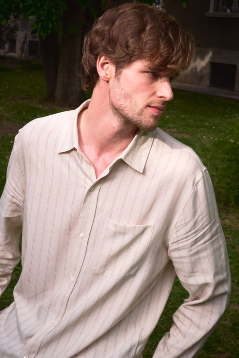beautiful young man in an old money style outfit in a garden