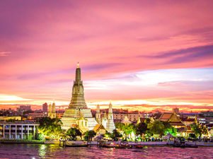 Wat Arun under a dramatic pink and purple sky at sunset in Bangkok