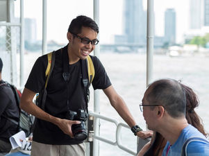 Walk-Talk-Photo photographer chatting with a guest by the Chao Phraya River in Bangkok