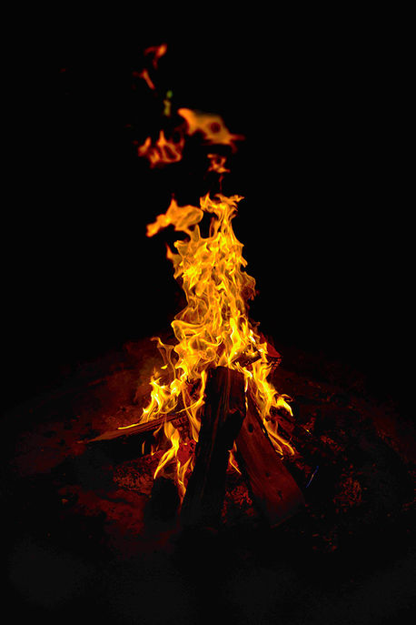 Fire – vivid orange flames rising against darkness in an abstract fine art photograph