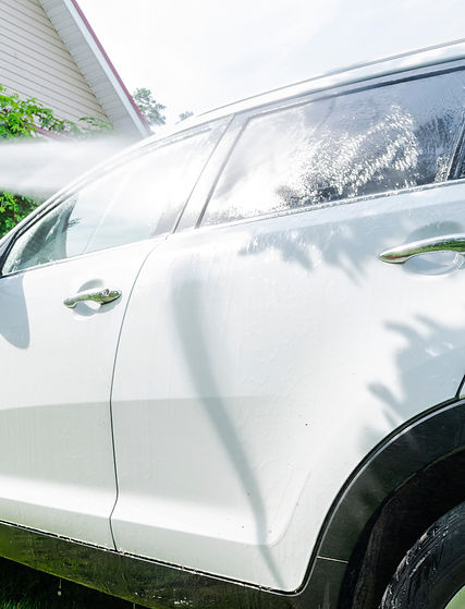 Manual car wash with pressurized water outside. Summer Car Washing. Cleaning car using hig