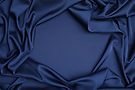 Crumpled dark blue silk fabric as background, top view Space for text.jpg
