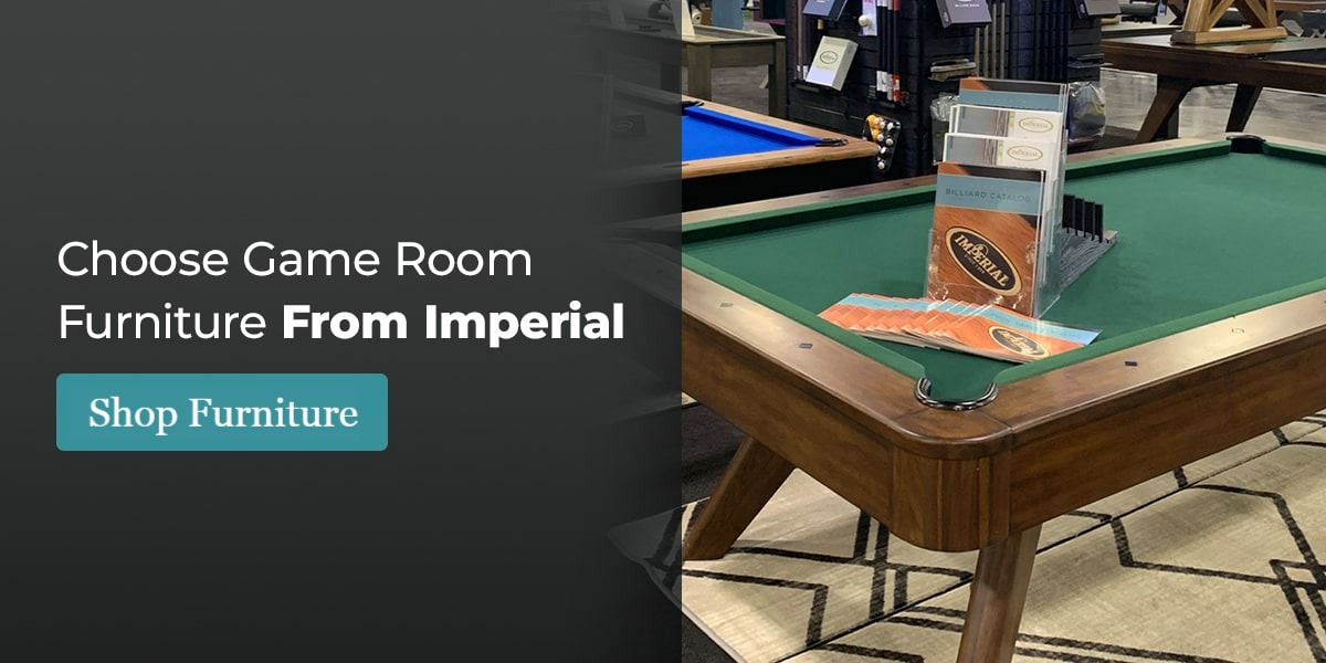 Pool table with green felt, brochures on top, showroom background. Ad text: Choose Game Room Furniture From Imperial. Shop Furniture.