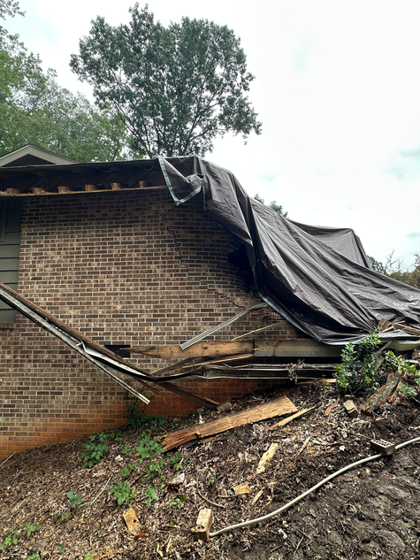 Severe roof damage caused by fallen tree