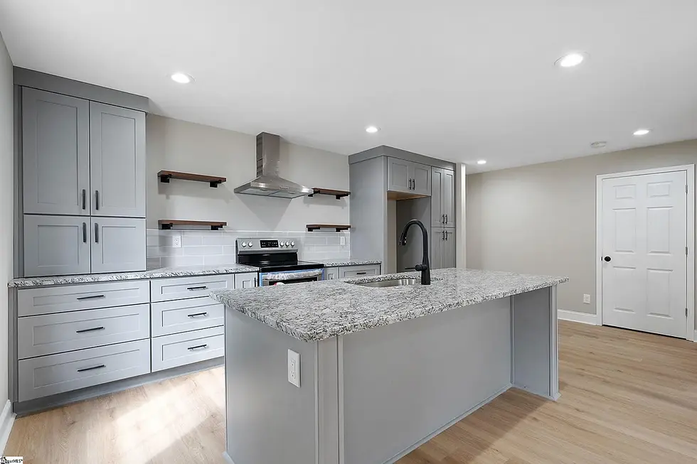 Remodeled kitchen with gray cabinetry, granite countertops, large island, and stainless steel appliances