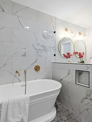 Luxury bathroom renovation with freestanding tub, marble tile, and custom finishes