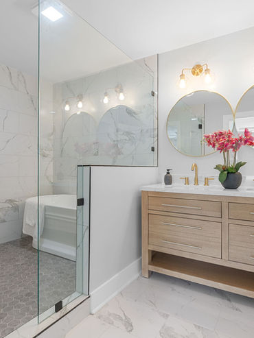 Primary bathroom renovation with glass shower, double vanity, and modern finishes