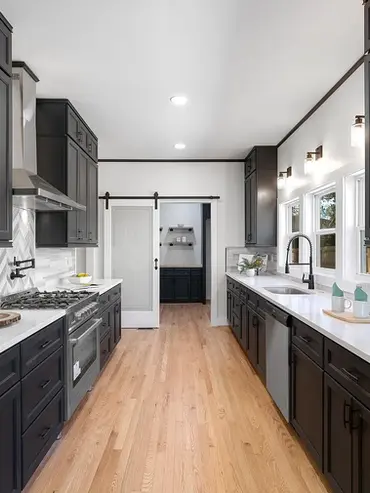 Kitchen renovation with dark cabinetry, large island, and hardwood flooring