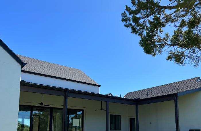 Seamless gutters installed on a residential home in Lago Vista, TX with light stucco siding.