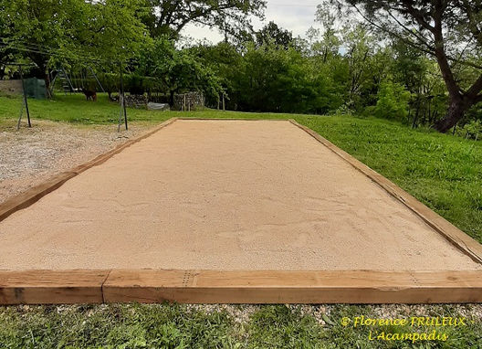 Jardin ombragé à l'Acampadis, Sud Ardèche, équipé de chaises et d'une balançoire, idéal pour la détente et les jeux, avec un vieux chêne datant de 1789 et un terrain de pétanque où l'on peut jouer en famille.