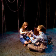 A father and daughter sit together on the floor in the underworld