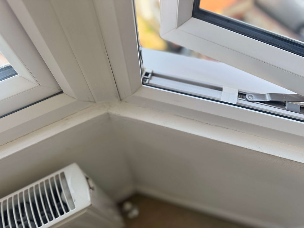 Close-up of full height hardwood shutter panels being fitted within an Bury St Edmunds bedroom bay window showing precise alignment across the bay angles and reveal edges