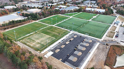 Aerial view of a soccer field featuring vibrant artificial grass, marked with white lines and goals at each end.