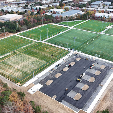 Aerial view of a soccer field featuring vibrant artificial grass, marked with white lines and goals at each end