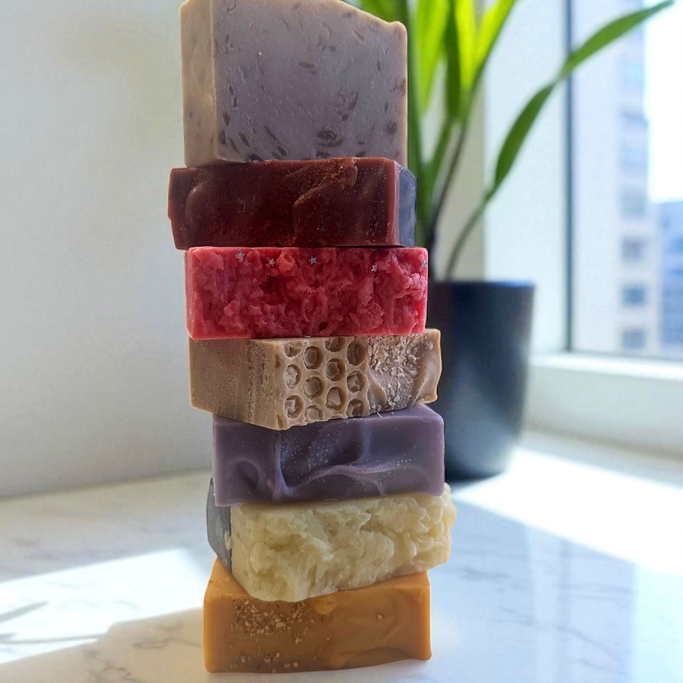 Stacked colorful soaps on display, next to a houseplant and a window.