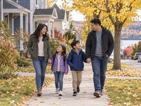 Parents and two school-age children walking along a small Canadian town residential street in autumn.