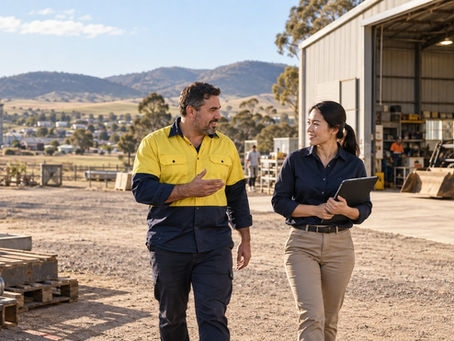 A regional employer and an overseas specialist walking through a practical Australian workplace near a small rural town in Australia