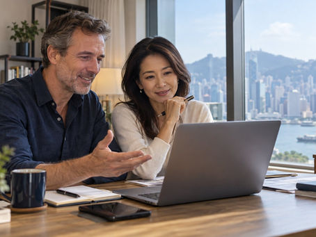 An international professional having a video consultation at a home desk with the laptop display turned away from the camera in Hong Kong