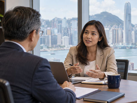 An international employee discussing a specific job offer with a human resources manager at a small meeting table in Hong Kong