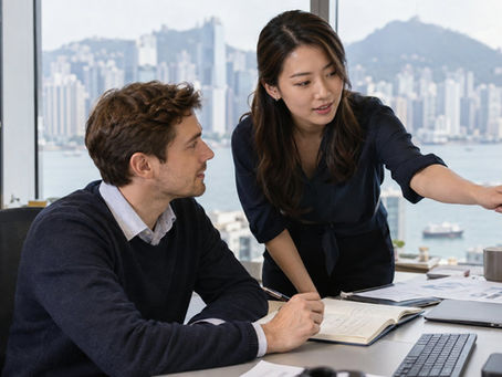 An overseas trainee learning a specific practical task from a workplace supervisor in a Hong Kong office