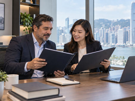 An employer and an overseas professional comparing two unmarked employment folders in a bright everyday company office in Hong Kong