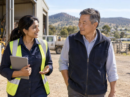 A regional employer and an overseas specialist walking through a practical Australian workplace near a small rural town in Australia