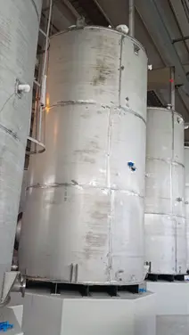 Large-scale vertical stainless steel bulk liquid storage silos used in industrial manufacturing and chemical processing facilities.