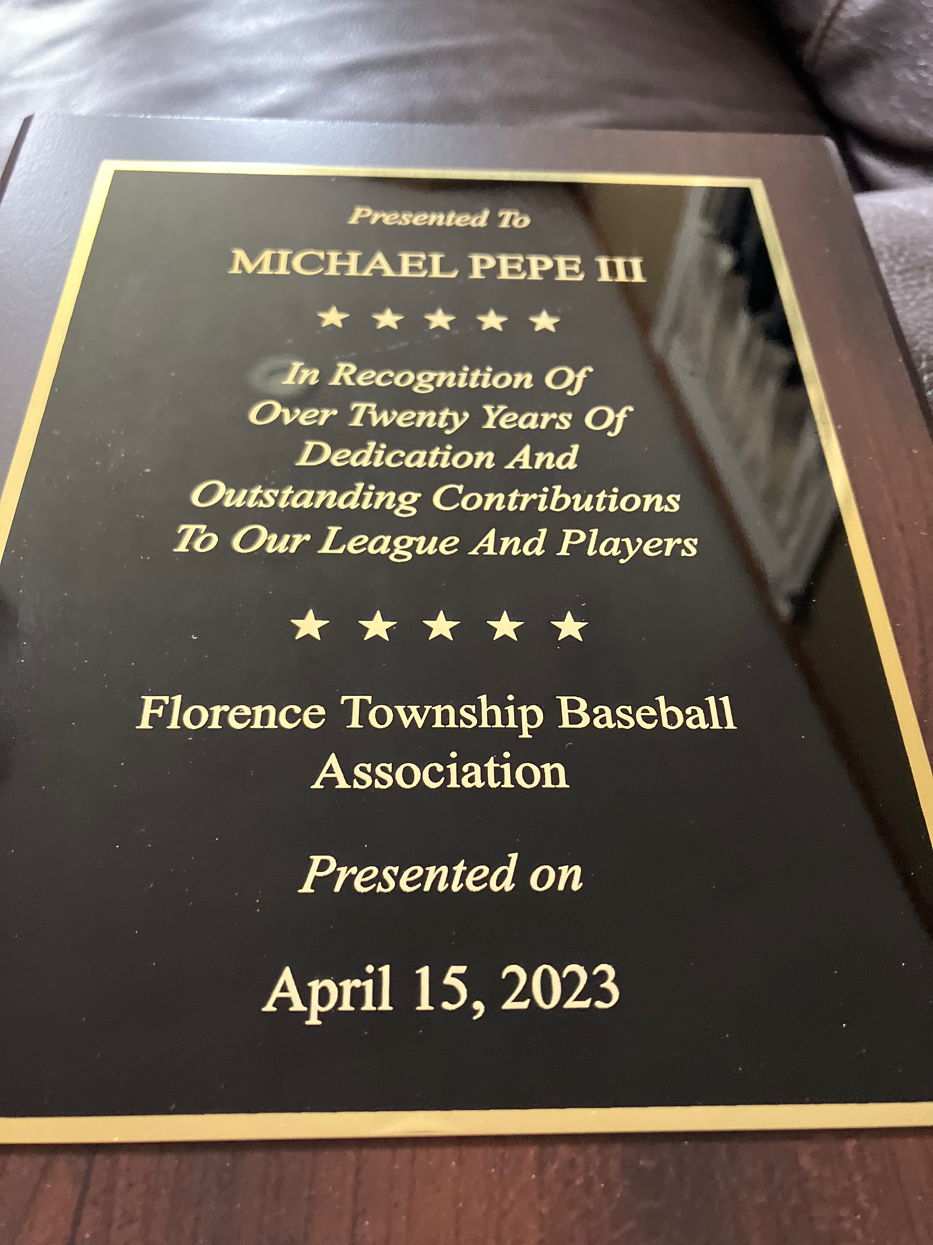  Close-up of a plaque awarded to Michael Pepe III from the Florence Township Baseball Association, recognizing over twenty years of dedication and contributions.