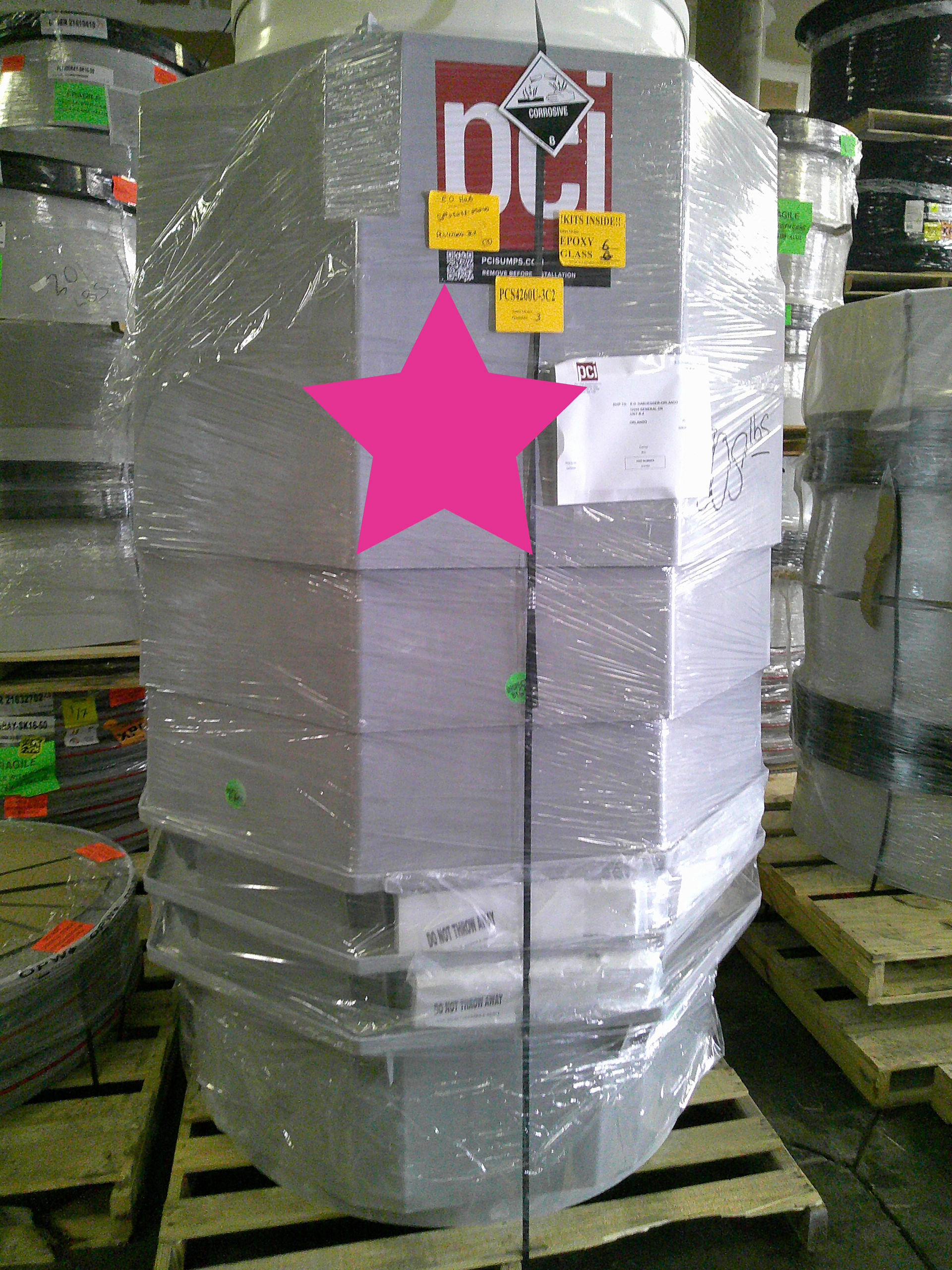 Large PCI containment sumps wrapped and palletized for a Wawa store project staging.
