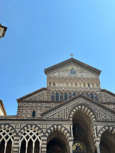 Duomo di Sant'Andrea's ornate, striped facade with arched entrance, blue sky.