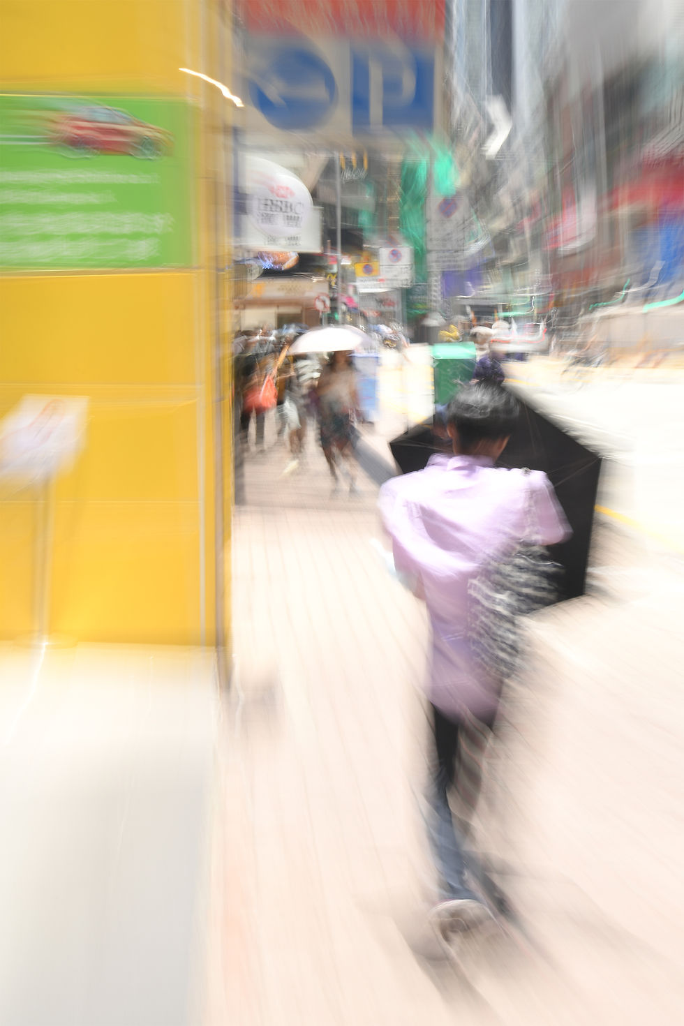 Blurred photo of a man with an umbrella walking on a street in Hong Kong